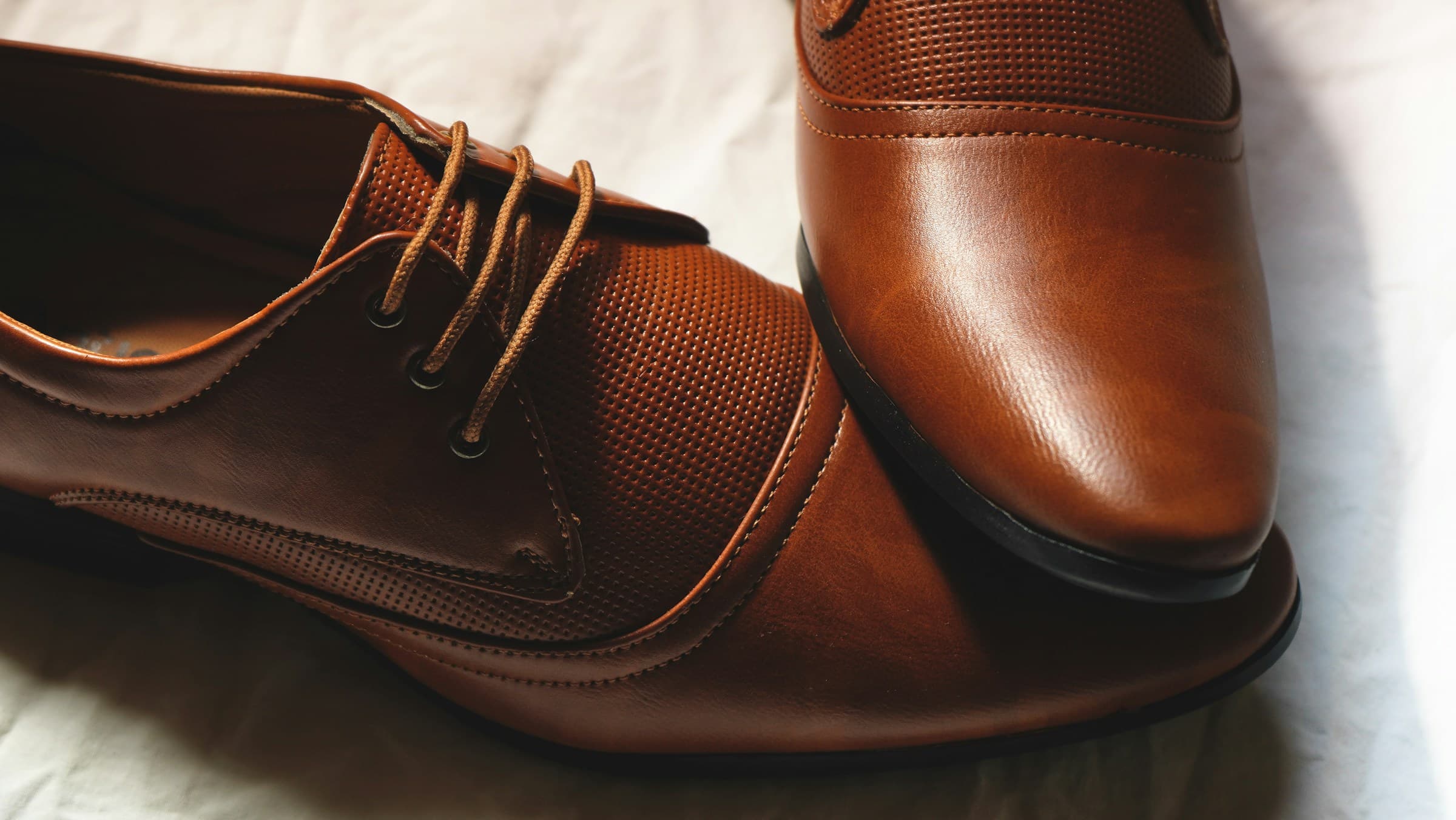 Close-up of polished brown leather lace-up shoes.